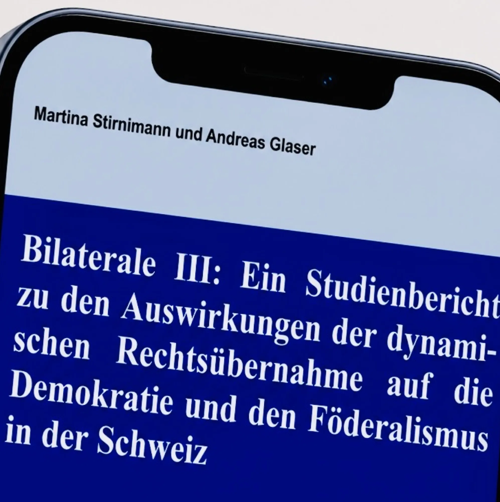 Smartphone mit dem Titelblatt der Studie «Bilaterale III: Ein Studienbericht zu den Auswirkungen der dynamischen Rechtsübernahme auf die Demokratie und den Föderalismus in der Schweiz» von Martina Stirnimann und Andreas Glaser