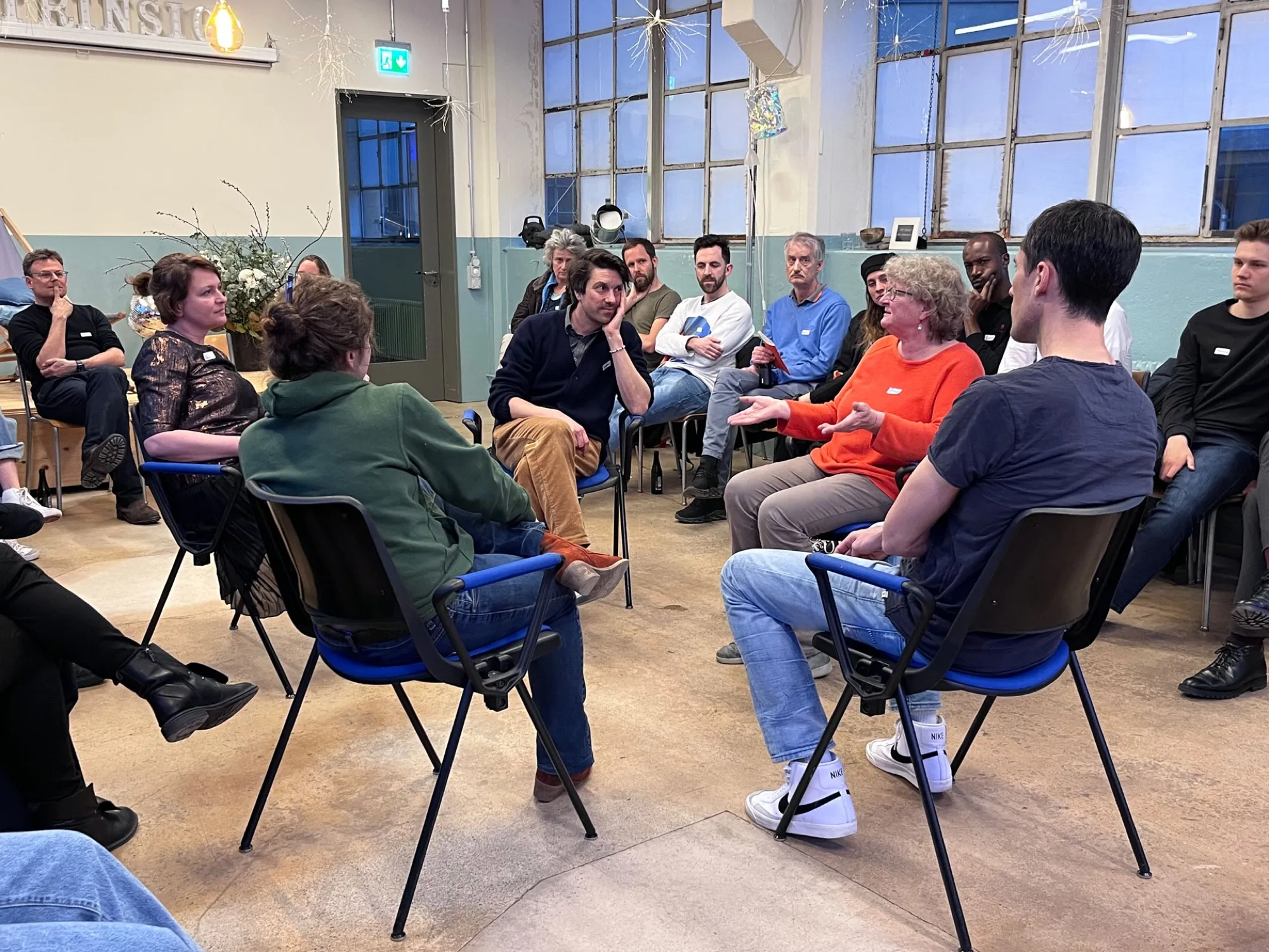 Gesprächsrunde im Stuhlkreis in einem Loft: Menschen diskutieren über eine neue Verfassung